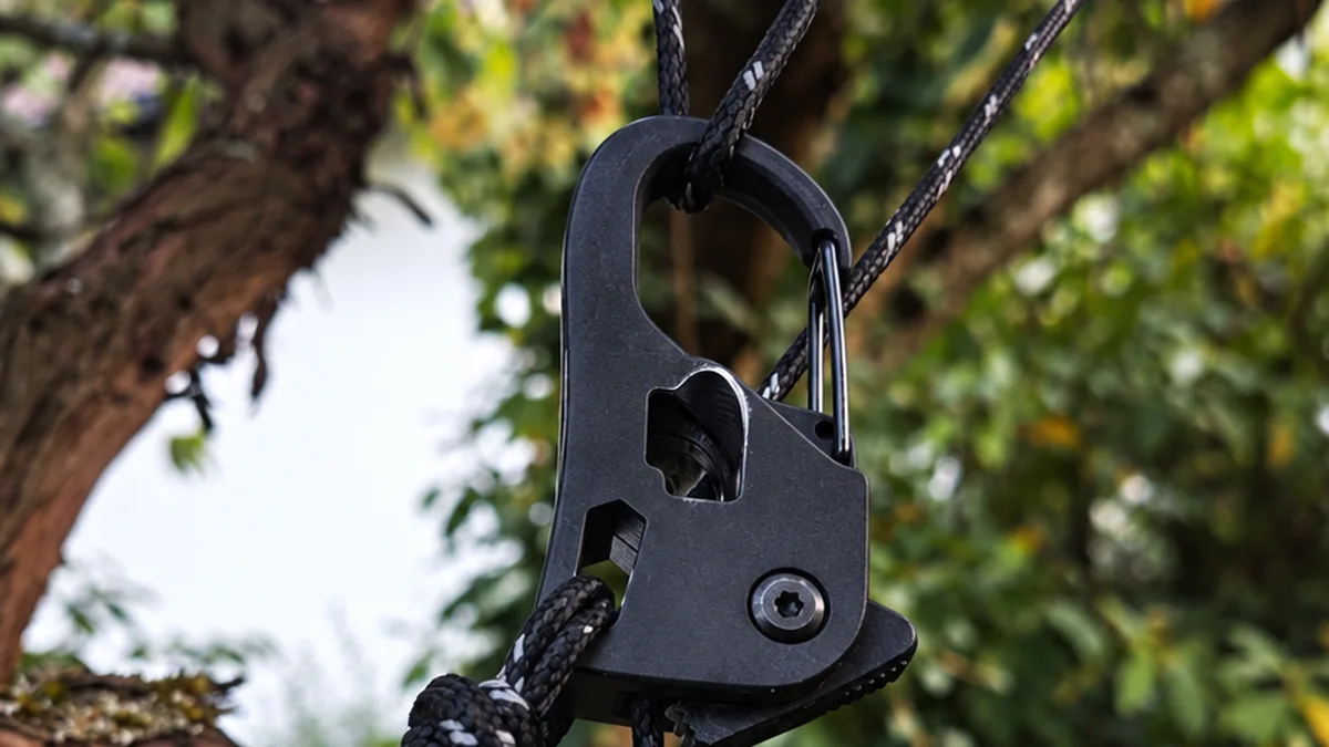 Seilspanner mit Karabiner im Einsatz an einem Baum, an drei Leinen befestigt